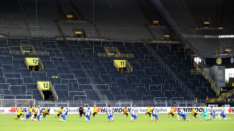 Borussia Dortmund and Hertha Berlin players take a knee ahead of kick-off in support of the Black Lives Matter movement