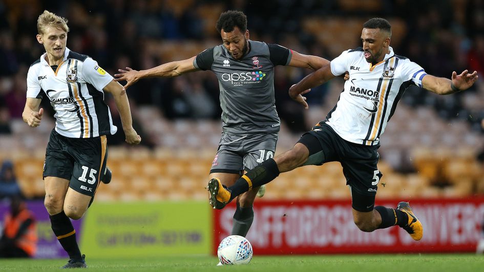 Port Vale's Nathan Smith, Leon Legge and Lincoln City's Matt Green battle for the ball